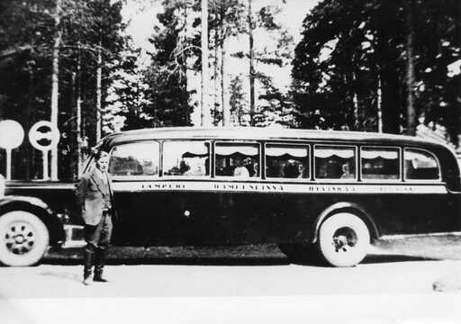 Väinö Säpyskä seisoo linja-auton vierellä vuonna 1936; auton kyljessä lukee Tampere, Hämeenlinna, Hyvinkää, Helsinki